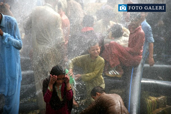 Sıcaktan bunalan Pakistanlılar suyla serinliyor