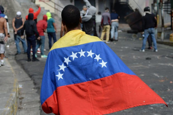 Venezuela'da sokaklar karıştı: Chavez heykelini yakıp astılar