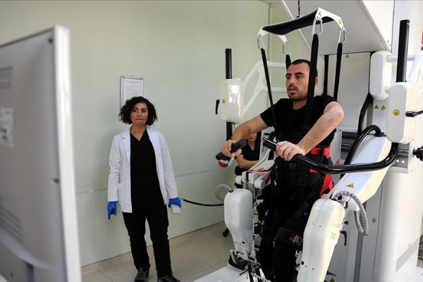 Gribin tetiklediği sendromla felç geçirdi, robotla yürümeye çalışıyor