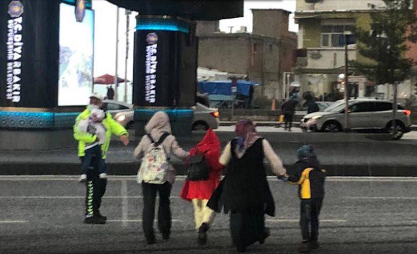 Diyarbakır'da doluya yakalanan anne ve çocukları trafik polisinin yardımıyla yolun karşısına geçti