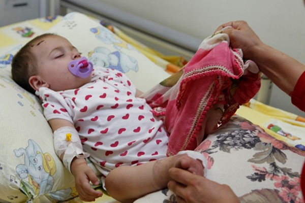 Ölen annesinin tülbentiyle uyuyor