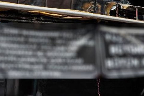 Yakılan işyerinde anlamlı pankart