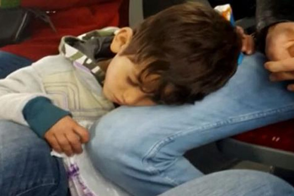 Mendil satan çocuk yorgunluktan yolcunun dizinde uyudu