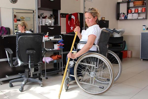 Mesleğini tekerlekli sandalye üzerinde icra ediyor