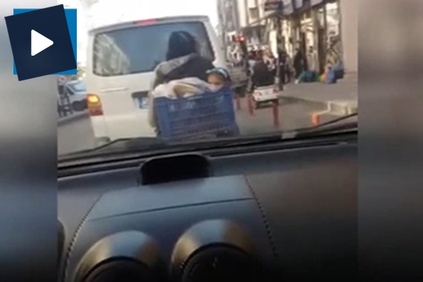 Çocuklarını sepette taşıyan motosiklet sürücüsü