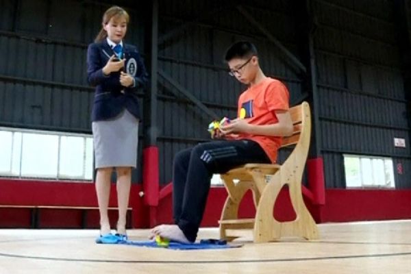 Elleri ve ayaklarıyla zeka küpü çözme rekoru kırdı