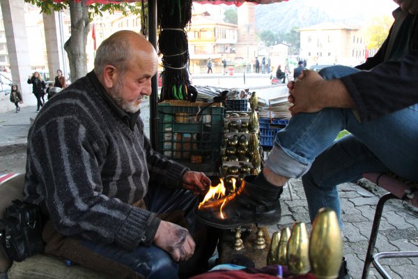 Ayakkabıyı ateşle boyuyor